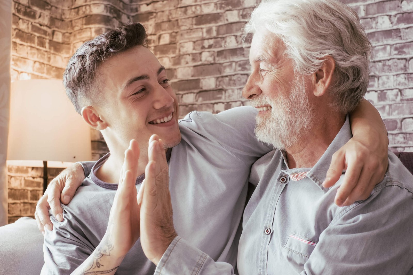 Young boy and his grandfather smile as they high five each other
