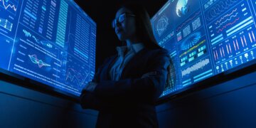 The businesswoman standing near the blue monitor